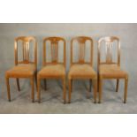 A set of four early 20th century satinwood dining chairs, marquetry inlaid with a floral design to