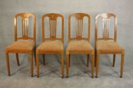 A set of four early 20th century satinwood dining chairs, marquetry inlaid with a floral design to