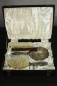 A boxed set of silver repousse scrolling and figural design brushes, mirror and comb. Hallmarked: