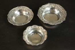 Three repousse Indian silver dishes with stylised floral and foliate design, one on three engraved