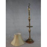 A 20th century turned brass standard lamp, on a circular base with a turned wood foot. H.164cm