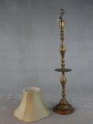 A 20th century turned brass standard lamp, on a circular base with a turned wood foot. H.164cm