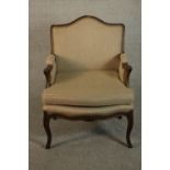 A French Louis XV provincial walnut fauteuil á la reine, with carved floral apron, cabriole legs,