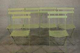 A set of six green painted metal folding garden chairs of slatted form.