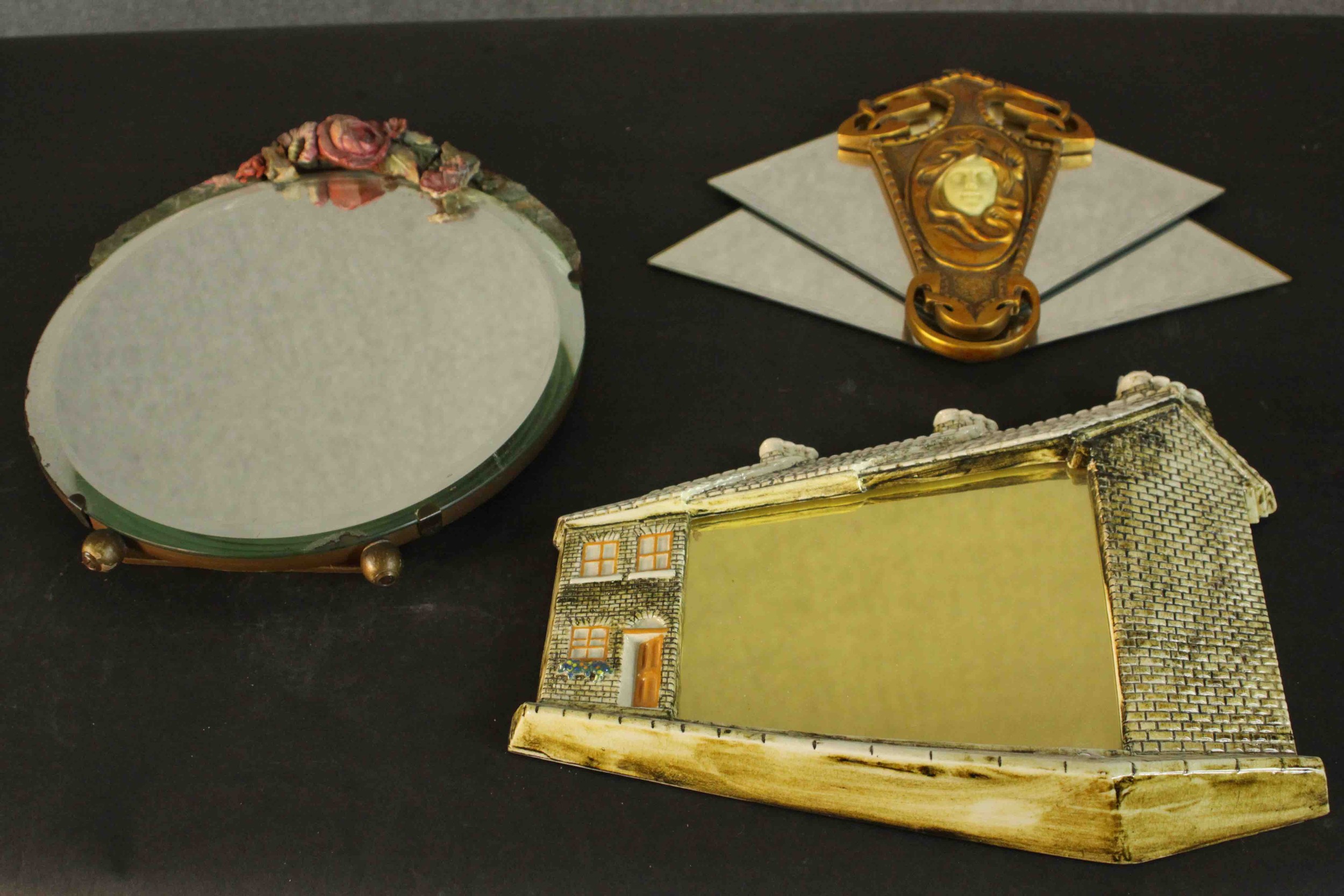 Three vintage mirrors, including a sculpted clay floral design mirror, an Art Nouveau style mirror