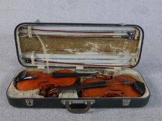 Two early 20th century violins in a leather carrying case. One made by Nicola Utili and one by Jay
