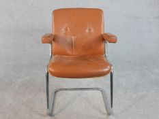 A cantilever office chair by Karl Dittert for Giroflex, with buttoned tan leather arms, seat