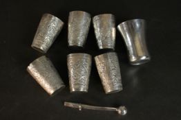 A collection of six small white metal (tests as silver) engraved foliate chai cups, a similar silver