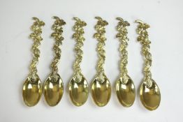 A set of six gold plated carved and engraved white metal (tests as silver) coffee spoons with vine