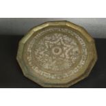 A Middle Eastern brass tray of dodecagon shape, with chased designs centered by a star. Dia.58cm.