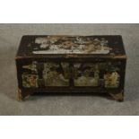 A Chinese lacquered chest, painted with various scenes to the top and front, with two cupboard doors