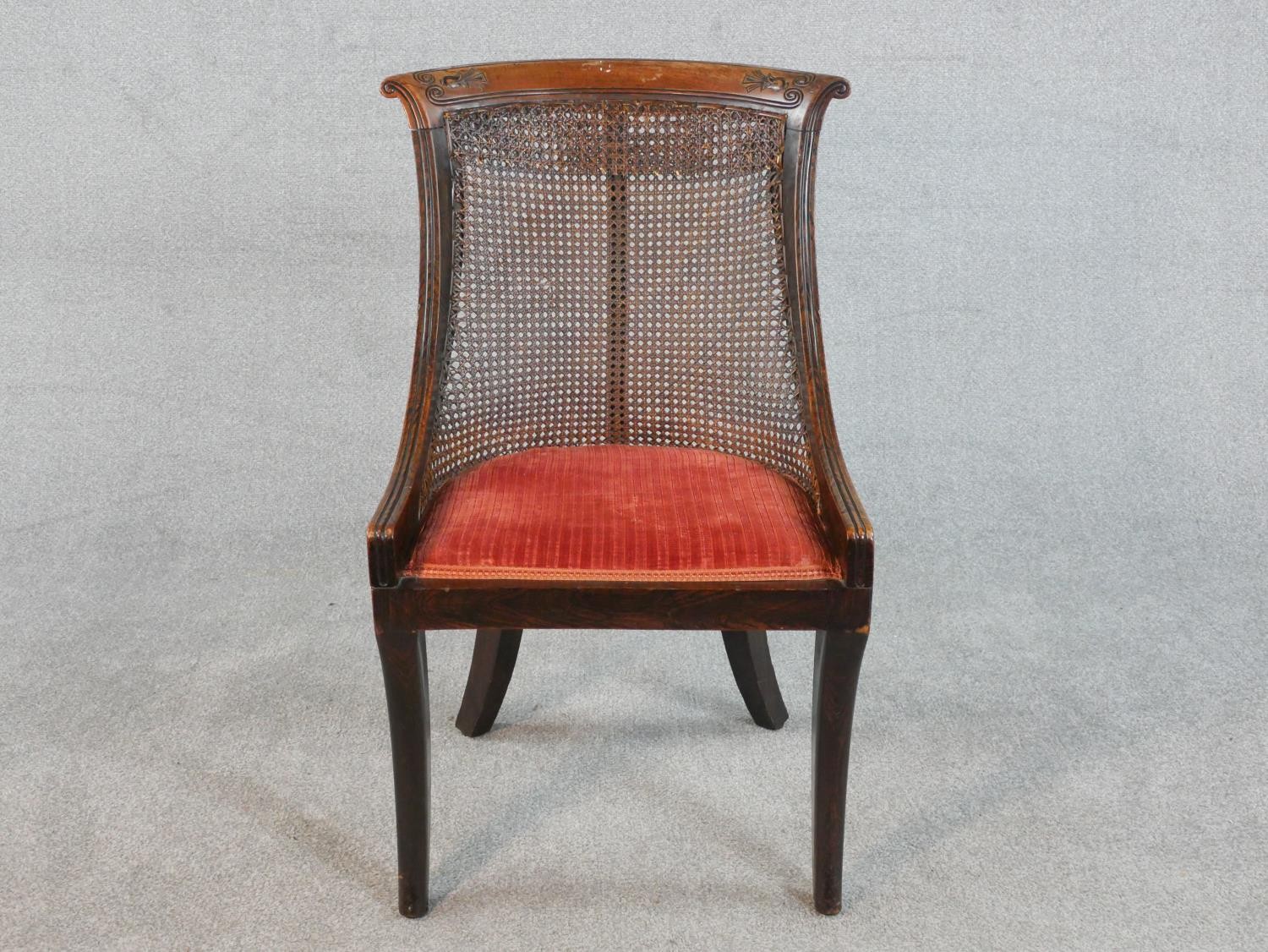 A Regency simulated rosewood bergere type side chair, the carved bar back over caning, above a red