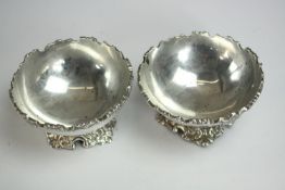 A pair of silver bowls on repousse cross form feet and shaped edges. Stamped silver. H.5 Dia.10cm.