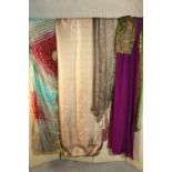 A collection of vintage fabric and textiles, including several vintage silk saris (pale peach one