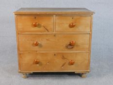 A small Victorian pine chest of two short over two long drawers with knob handles, on turned feet.