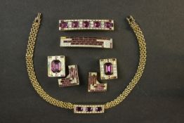 A suite of purple and clear paste costume jewellery, including two bar brooches, two clip