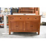 A contemporary hardwood sideboard with two drawers above panel doors on block supports. H.91 x W.150