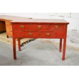 A C.1900 Chinese red lacquered side table fitted with an arrangement of drawers on square section