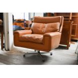 A 1970s vintage light tan leather upholstered armchair with swivel and reclining action on a four