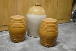 Two honey glazed stoneware cask barrels along with a demijohn.