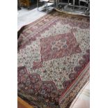 A large Persian style carpet with central medallion on a biscuit ground with floral decoration