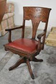 A late 19th century oak framed desk armchair with tilt and swivel action on a cabriole base. H.97