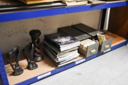 A shelf of items including Two collections of Postcards, Treen and Auction Catalogues.