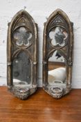 A pair of moulded Gothic style wall mirrors each fitted with a candle sconce.