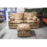 A two seater floral upholstered sofa and matching footstool. H.75 x W.165cm