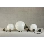 A set of three Victorian style contemporary hanging globe lights, with milk glass shades and bronzed