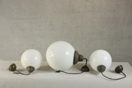 A set of three Victorian style contemporary hanging globe lights, with milk glass shades and bronzed