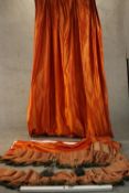 A pair of silk mix burnt orange curtains along with two orange silk pelmets with silk tassel