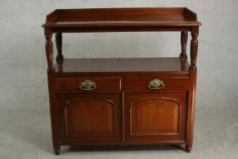 A Victorian style walnut buffet, the top with a 3/4 gallery on reeded columns over two short drawers