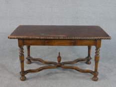 A continental walnut table, the rectangular leather top with brass studs to the edge, over a