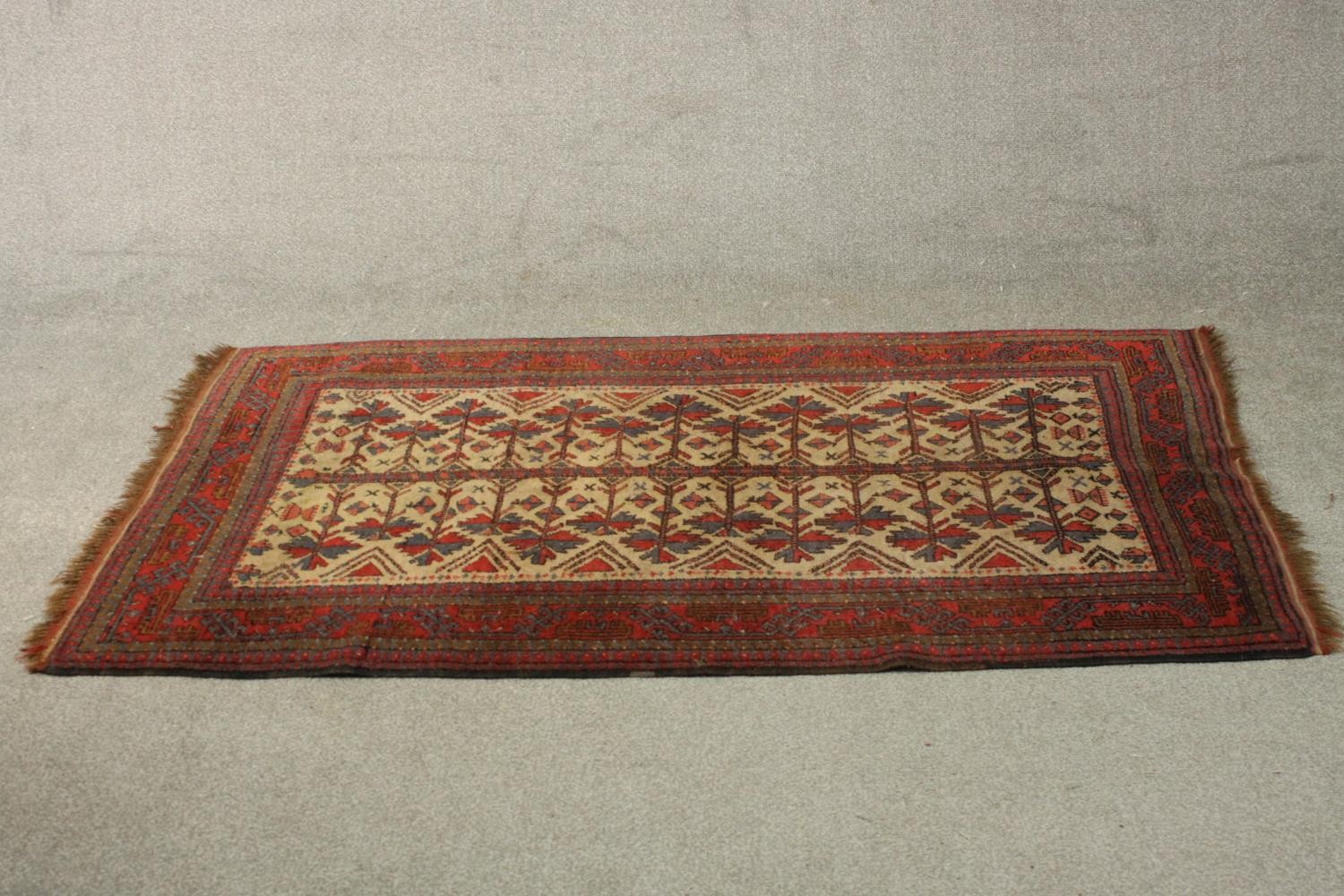 A beige ground hand made Belouch rug. L.180 W.102cm.