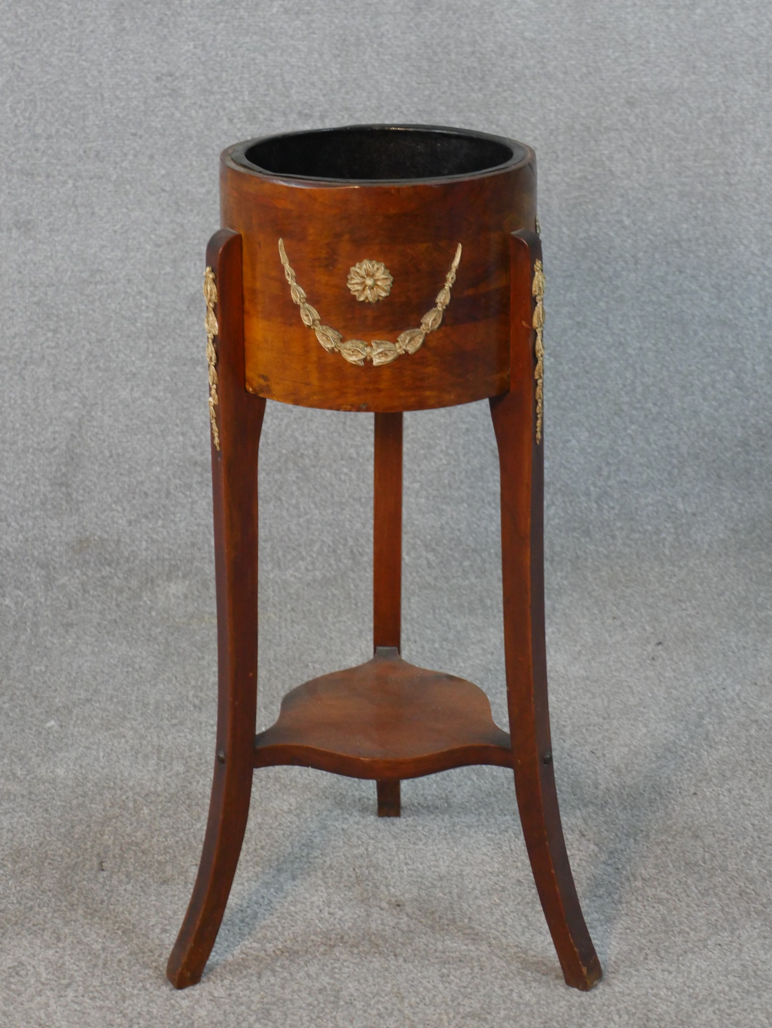 A 20th century fruitwood jardiniere stand, the circular top with gilt metal mounts, on three splayed