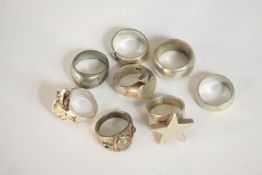 A collection of nine silver rings, including one sculpted as an eagles head, one with an Egyptian