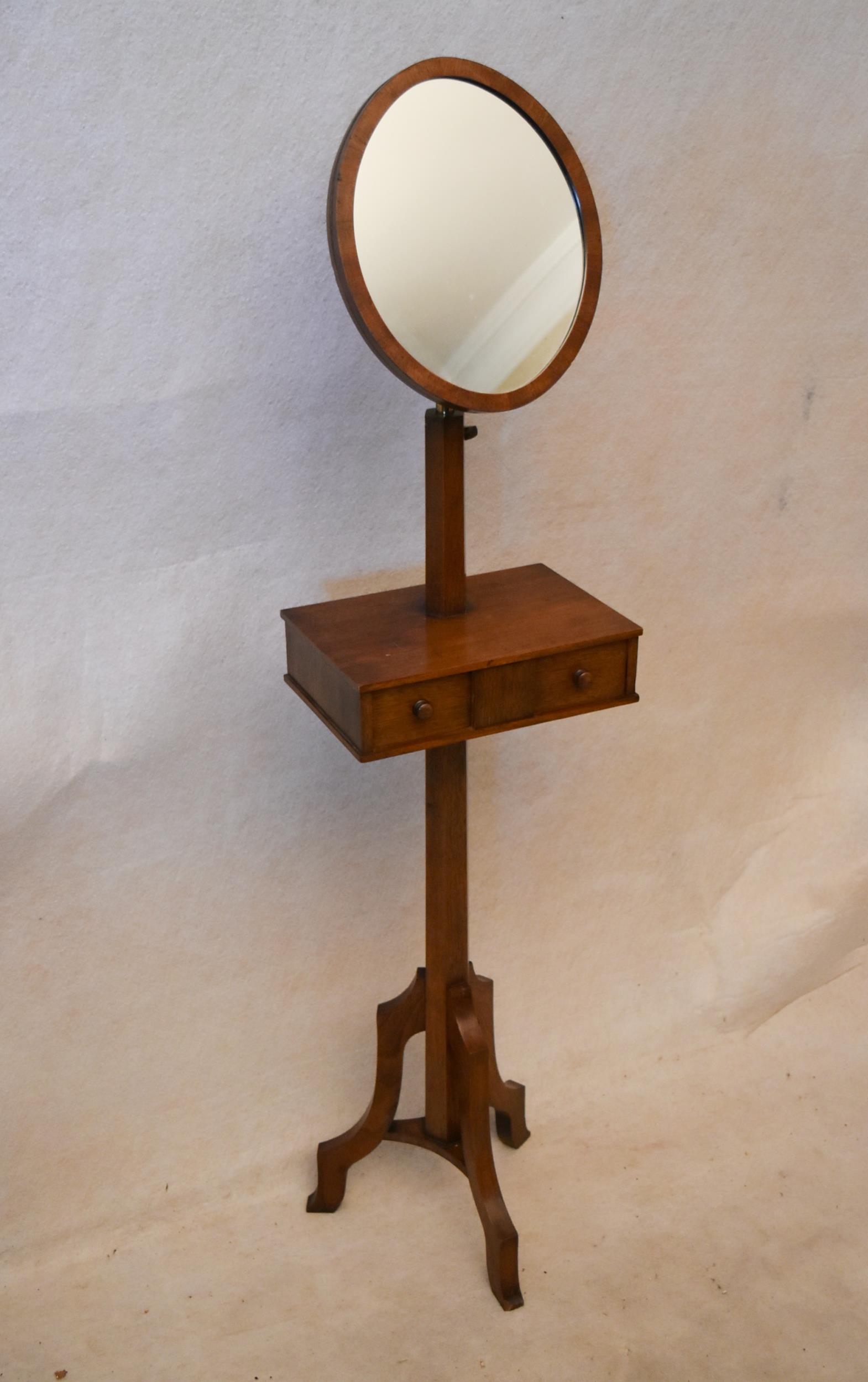 An early 20th century oak gentleman's shaving stand, with an oval mirror on a telescopic frame,