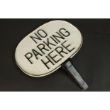 A painted cast iron 'No Parking Here' sign with relief letters and border. H.43 W.37cm.