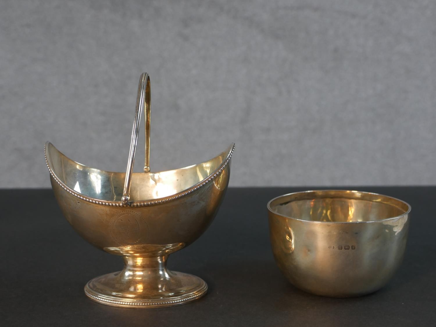 A Georgian sterling silver boat shaped sugar basket with handle and engraved cartouche along with