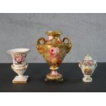 Three 19th century hand painted porcelain urns, one with gilded rams head handles and rose design (