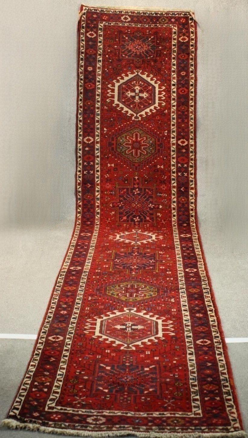 A hand made red ground Persian Heriz runner. L.440 W.100cm.