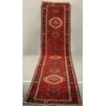 A hand made red ground Persian Heriz runner. L.440 W.100cm.