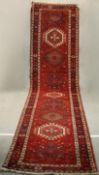 A hand made red ground Persian Heriz runner. L.440 W.100cm.