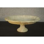 A late 19th/early 20th century oval marble tazza, with a carved border and a lobed side, on a