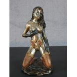 An Art Deco style patinated brass erotic figure of a nude kneeling woman in stockings and