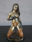 An Art Deco style patinated brass erotic figure of a nude kneeling woman in stockings and