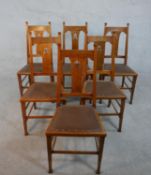 A set of six Arts and Crafts oak dining chairs with pierced foliate central splats on square