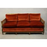 An Edwardian Adam inspired mahogany three seater bergere sofa, upholstered in red velour with