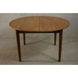 A circa 1960's teak extending dining table with a butterfly leaf, on tapering cylindrical legs. H.73